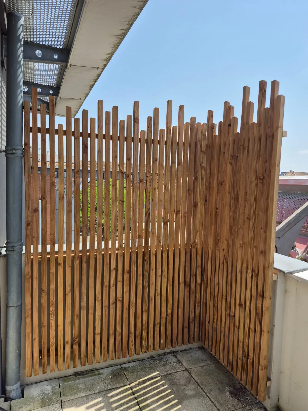 Brise-vue en lames de bois sur une terrasse