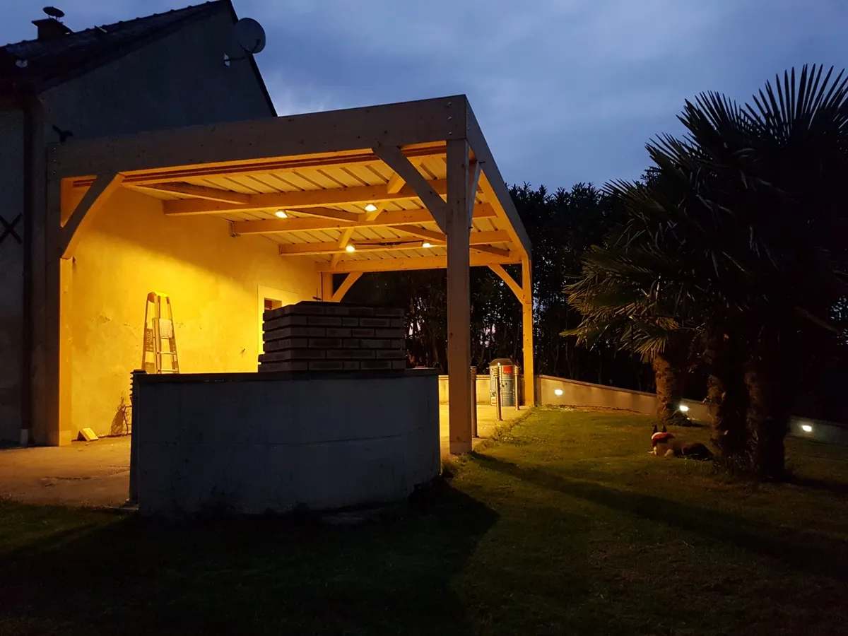 Pergola en bois éclairée de nuit dans un jardin