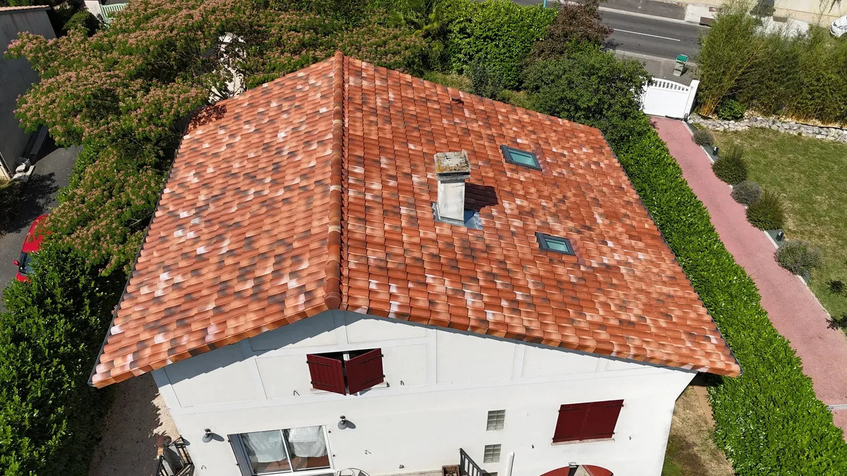 Toiture en tuiles terre cuite rénovée avec fenêtres de toit, vue drone